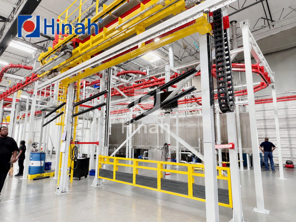 Overhead conveyor of an automatic powder coating line carrying parts through the plant